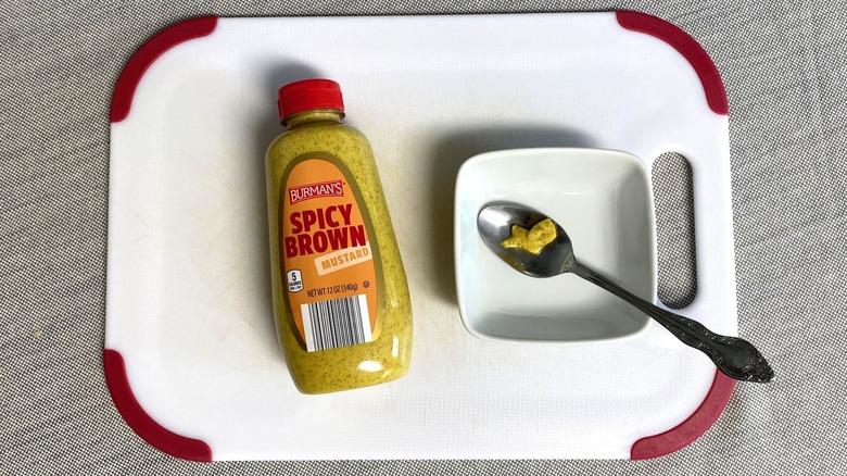 Burman's Spicy Brown Mustard on a table next to a sample in a spoon
