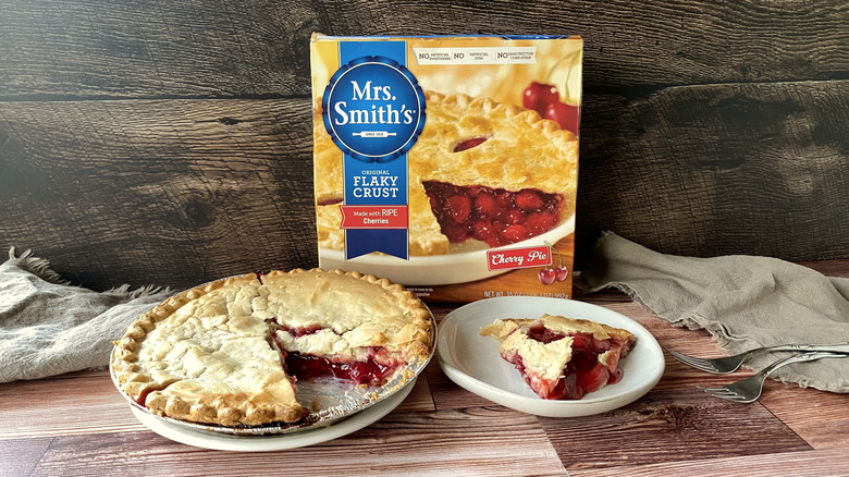 Mrs. Smith's cherry pie in the pan with a slice on a plate in front of the box