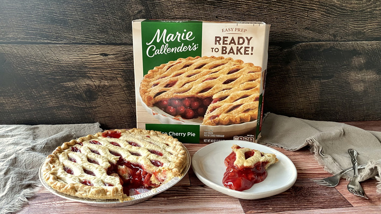 Marie Callender's lattice cherry pie in the pan with a slice on a plate in front of the box