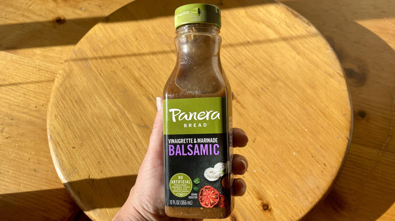 Hand holding bottle of Panera Bread Balsamic Dressing