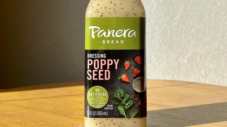 Close-up of label on a bottle of Panera Bread Poppy Seed Dressing on wood table