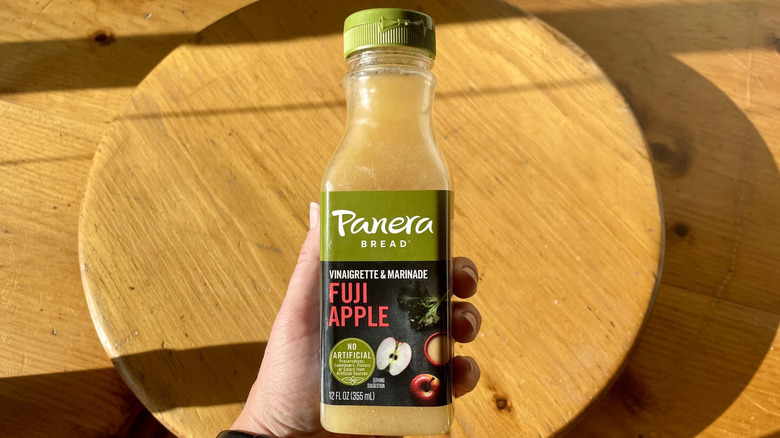 Hand holding bottle of Panera Bread Fuji Apple Dressing