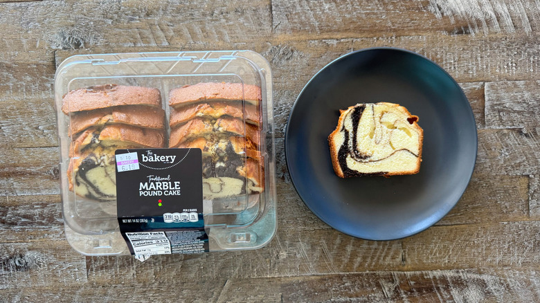 black plate with slice of marble pound cake on wooden surface