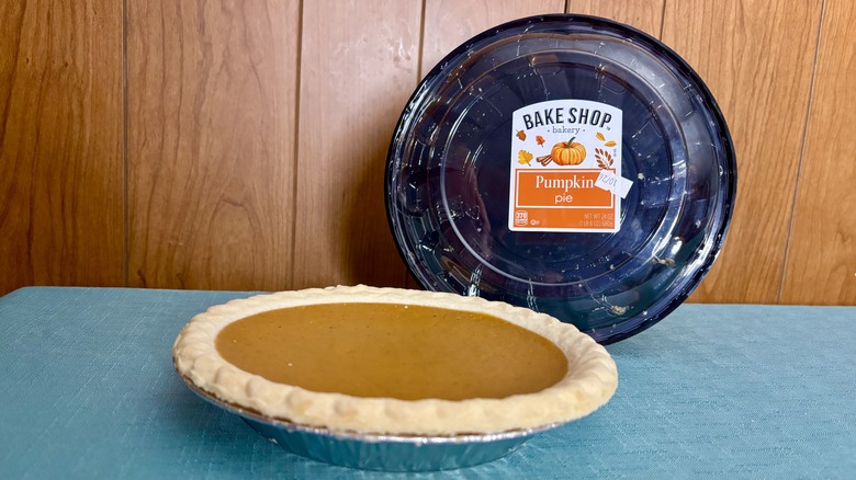 pumpkin pie sits in pie tin in front of empty packaging
