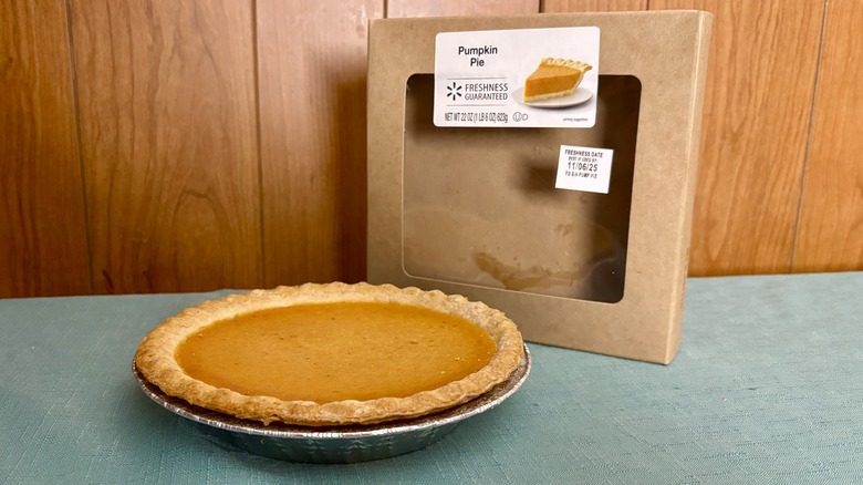 pumpkin pie in a pie tin in front of empty packaging
