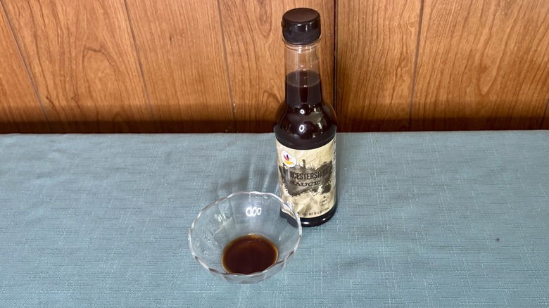 A small glass dish with Worcestershire sauce covering the bottom - a bottle of Stop & Shop Worcestershire Sauce stands behind the dish