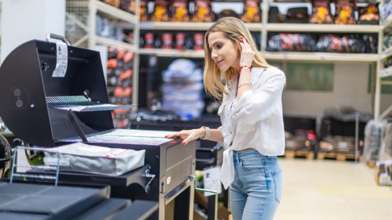 A woman considering a grill in a store