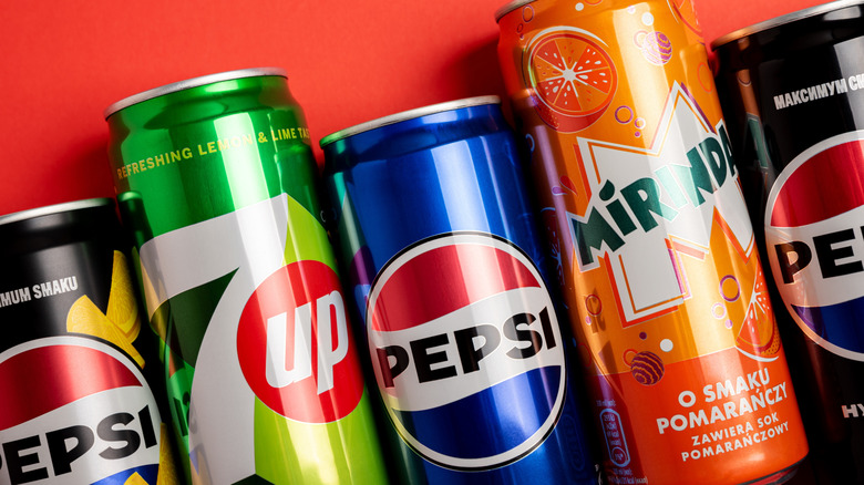 A mix of pepsi-co soda cans in a row