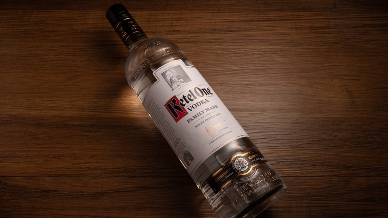 Top down view of a Ketel One vodka bottle lying down on a wood surface