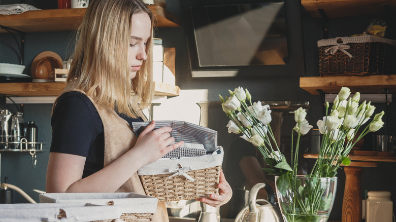 Woman holding basket as she declutters kitchen