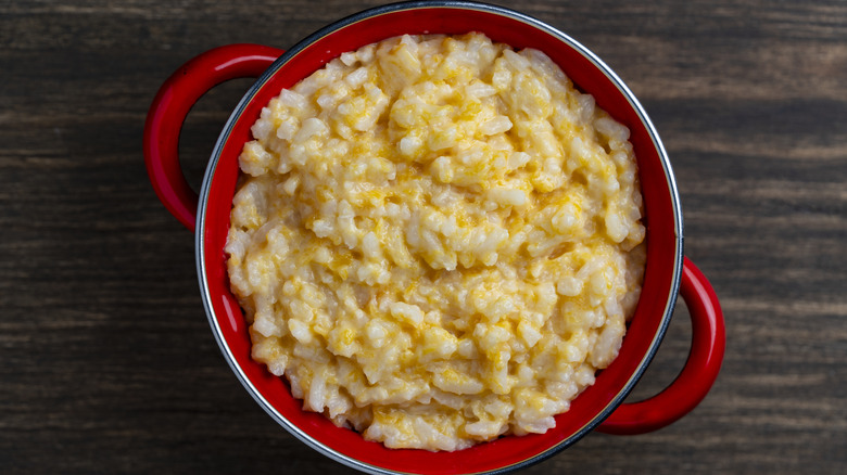a red pot with cheesy risotto