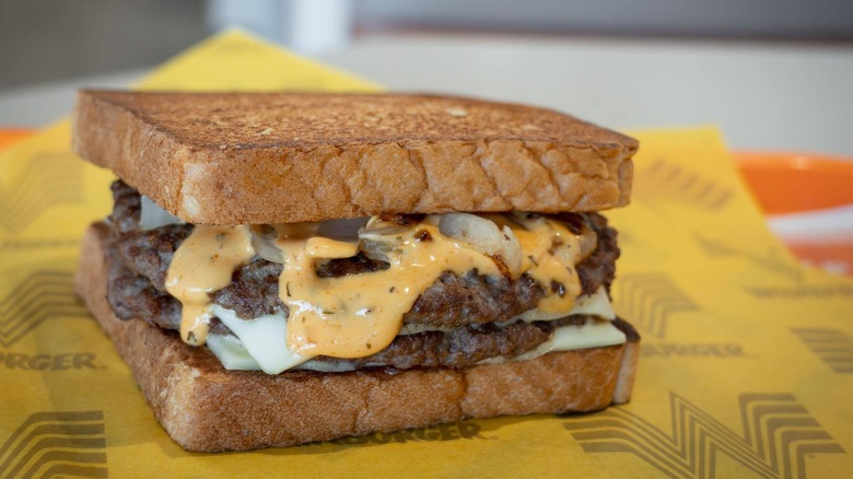 Texas toast patty melt on yellow parchment paper with Whataburger logo