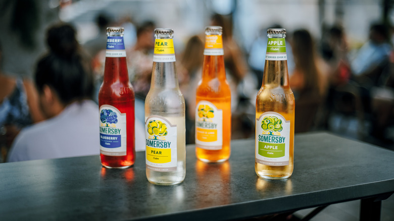 Four unopened Somersby ciders sit on a bar, from left - Blueberry, Pear, Mango & Lime, and Apple