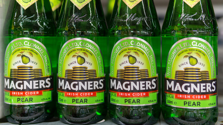 Four bottles of Magners Irish Cider pear flavor in a row
