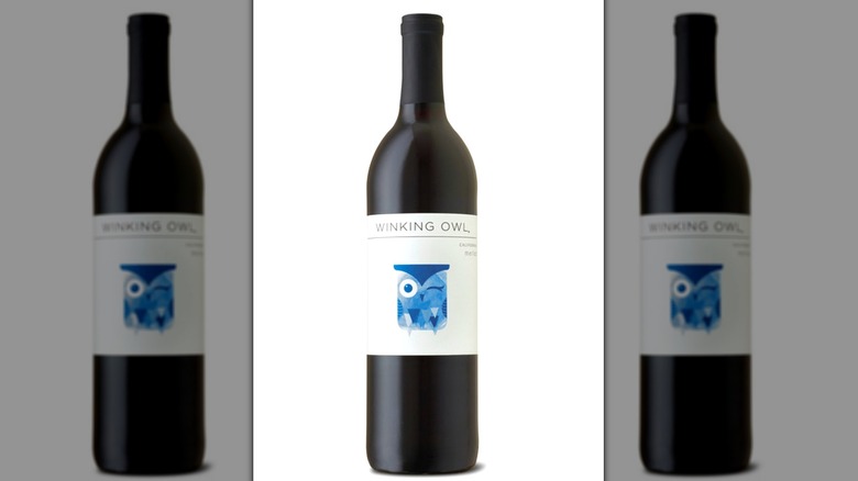 A bottle of Winking Owl merlot against a white background