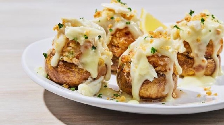 A plate of Crabby Stuffed Mushrooms dripping with melted cheese at Red Lobster