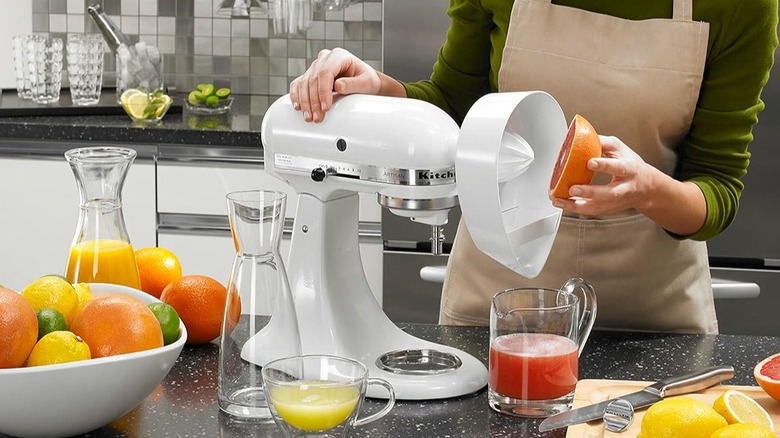 Person holding grapefruit up to mixer to make juice