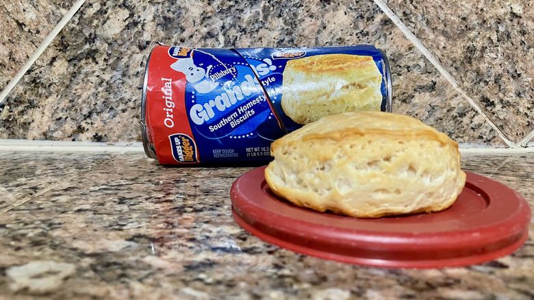 Opened can of Pillsbury Grands! Southern Homestyle Original Biscuits with a cooked one in front