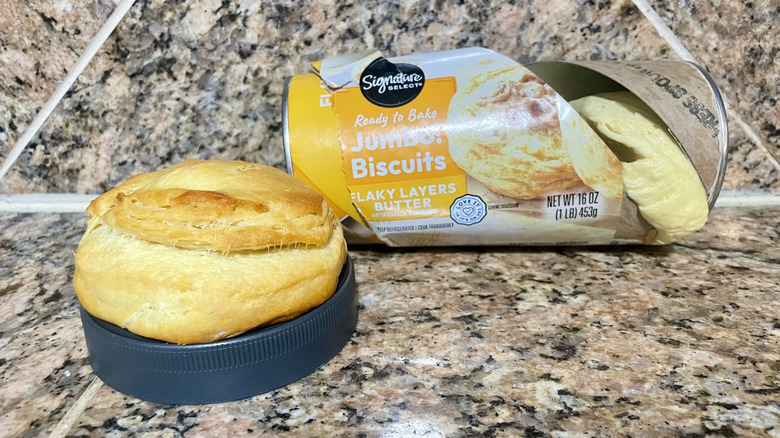 Opened can of Signature Select Butter Jumbo! Biscuits with a cooked one alongside