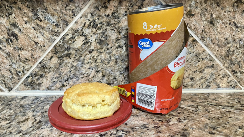 Opened can of Great Value Butter Flavor Flaky Jumbo Biscuits with a cooked one alongside