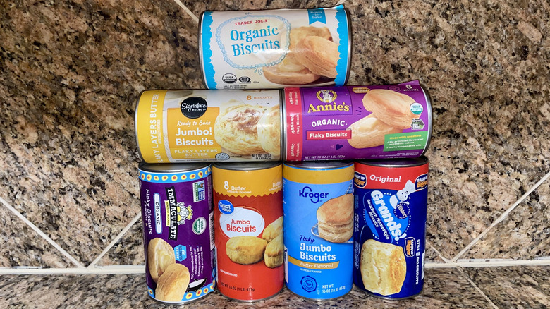Collection of different canned biscuits stacked on a marble counter