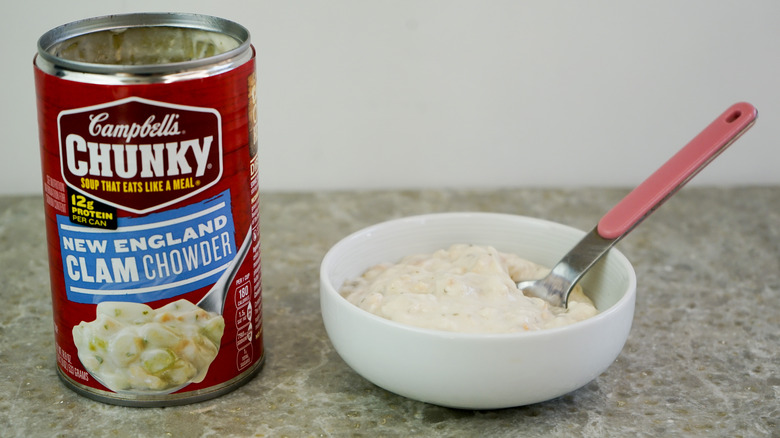 Campbell's Chunky New England Clam Chowder next to bowl with chowder and spoon