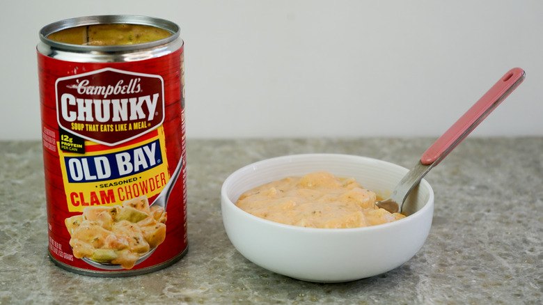 Campbell's Chunky Old Bay Seasoned Clam Chowder next to bowl with chowder and spoon