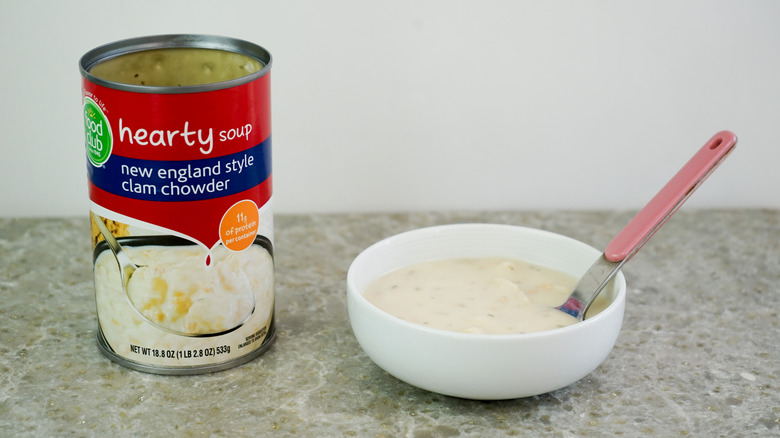 Food Club Hearty Soup New England Style Clam Chowder next to bowl with chowder and spoon