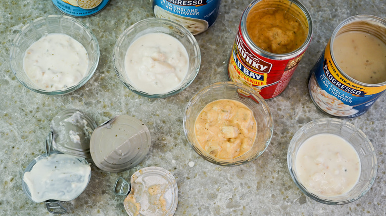Four bowls of clam chowder with cans and lids from above