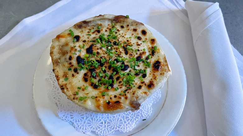 The French onion soup from Boucherie on a white plate