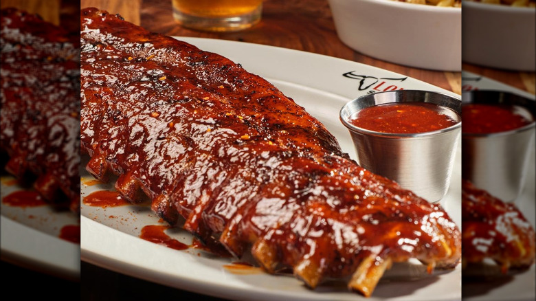A plate of baby back ribs and sauce