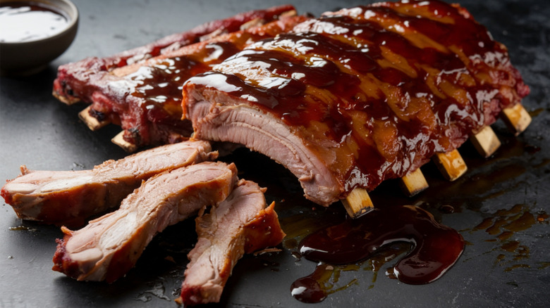 A rack of ribs on a black plate.