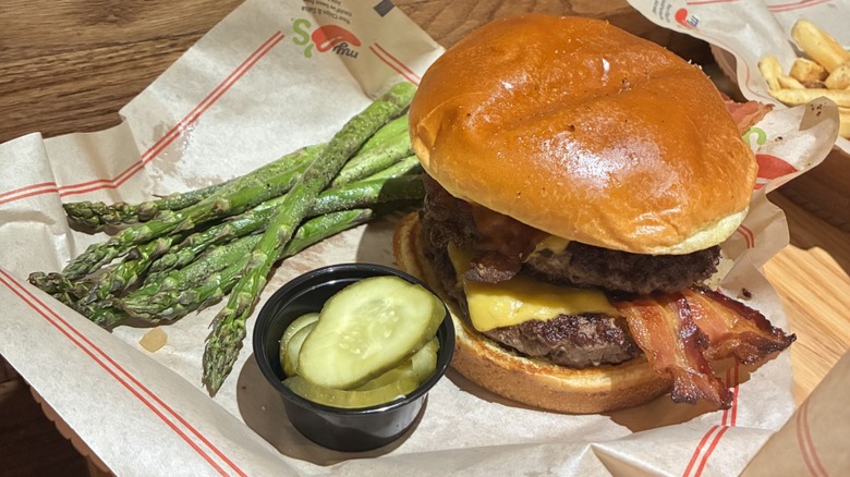 Bacon Rancher Burger alongside pickles and asparagus