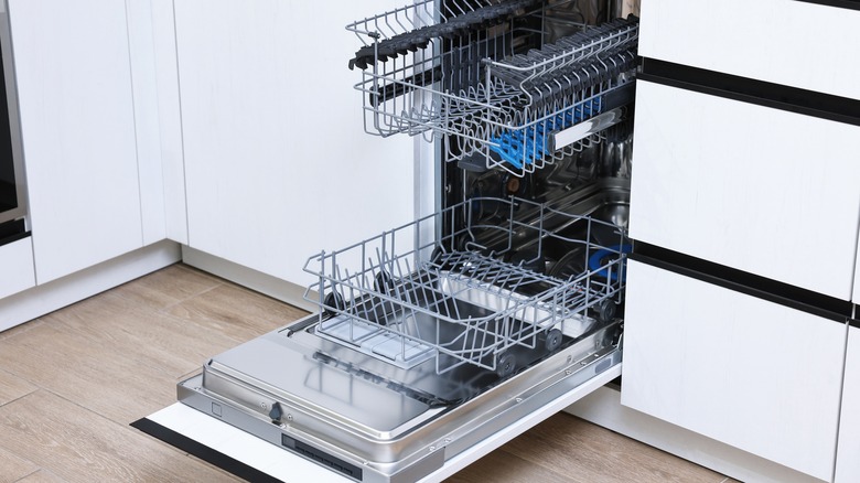 Open clean empty dishwasher in kitchen.