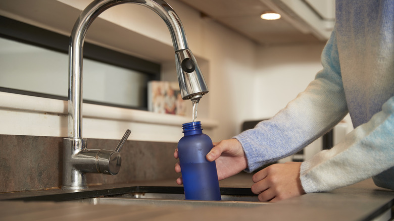 Filling up a water bottle in sink