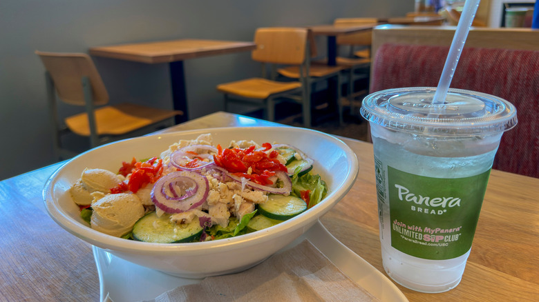 a salad and a filled drink on a table at a Panera restaurant