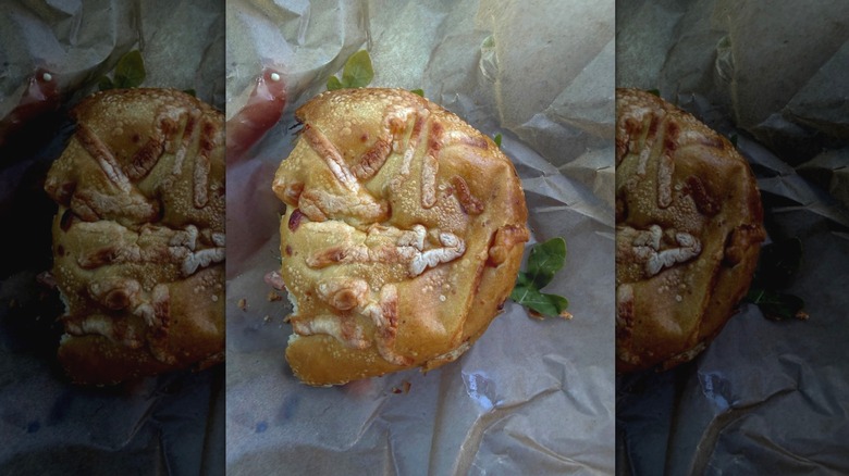 a shapeless, warped Asiago bagel from Panera Bread in a greasy wrapper