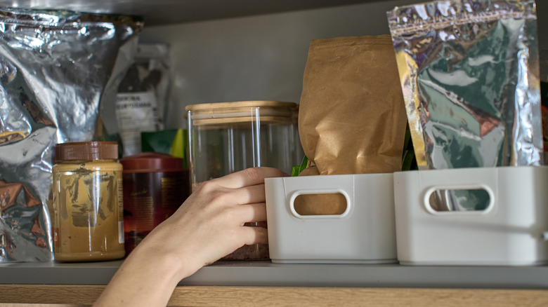 Person moving things around in a pantry