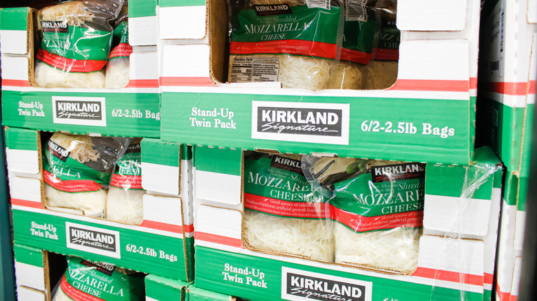 Several large bags of Kirkland mozzarella in cardboard containers at Costco