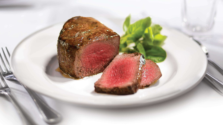 A cross-section of Capital Grille's Filet Mignon against a white plate and white table setting