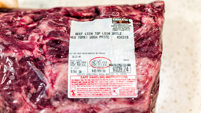 Prime beef top loin sirloin meat steak as whole roast New York strip steak by Costco Kirkland brand with closeup of price and sell by date on label