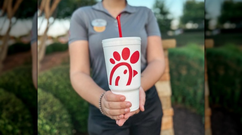 Chick-fil-A employee holding a cup of sweet tea