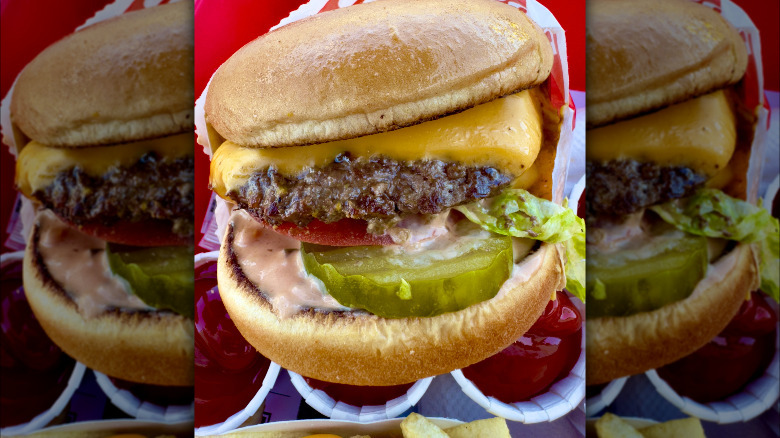 Close-up image of an animal style burger with extra sauces and toppings