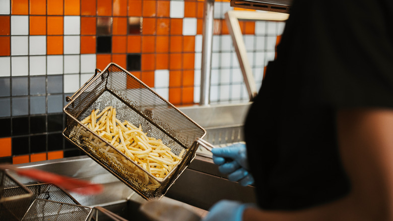 A Five Guys employee cooking fries