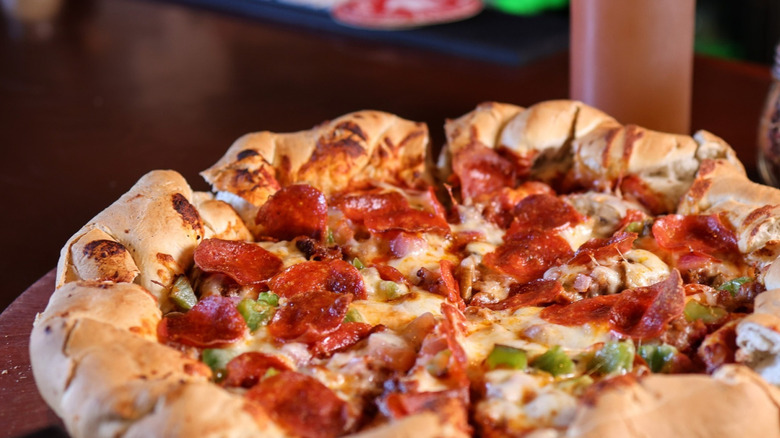 Beau Jo's Colorado Mountain Pie with lots of toppings and a braided crust on a wooden serving board