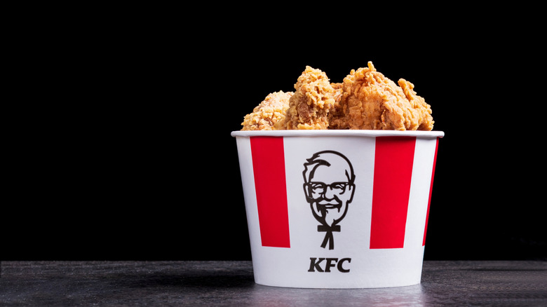 A bucket of KFC chicken on a black background
