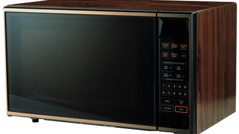 1980s microwave with faux-wood panels.