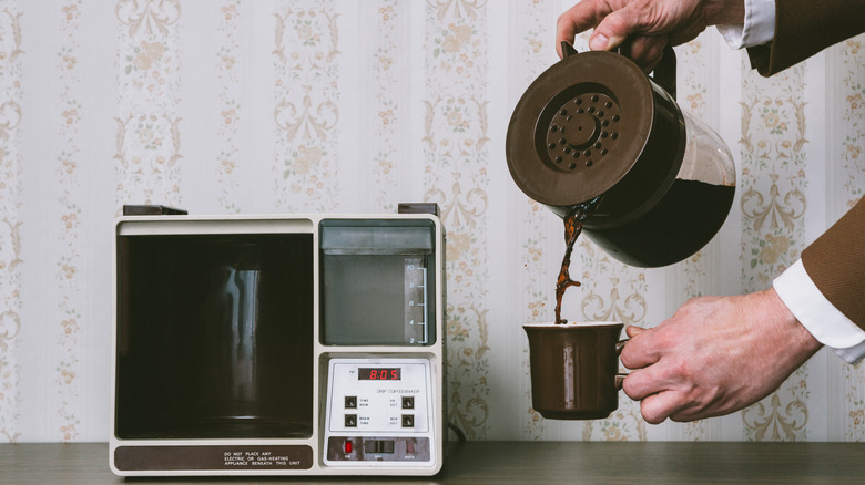 Person pouring cup of coffee.