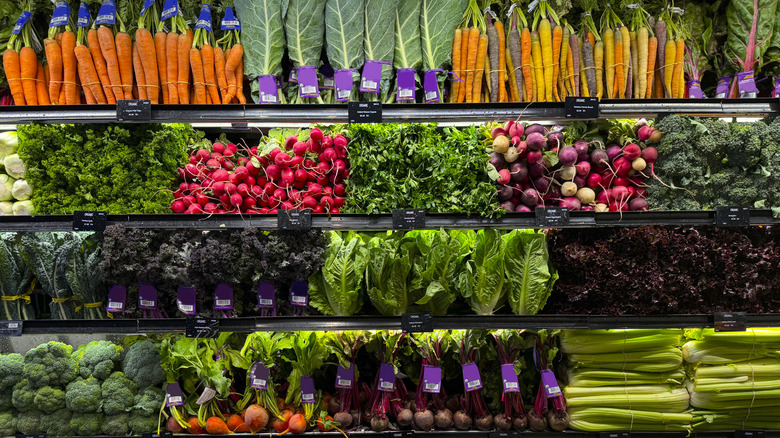 Grocery store shelves full of colorful, fresh veggies