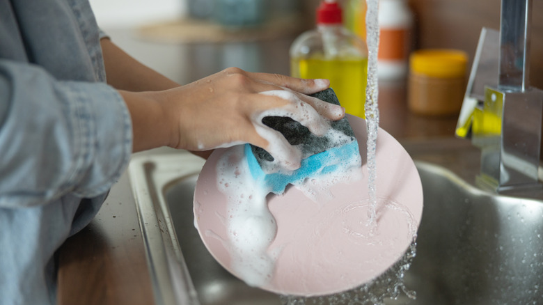 Someone scrubs dishes in the sink